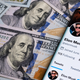 A pile of 100 dollar bills and a smartphone bearing Elon Musk's Twitter page.